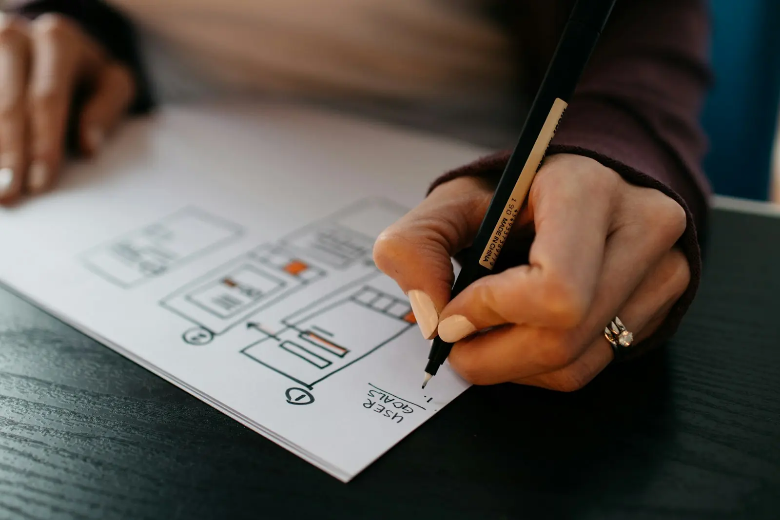 Hand drawing a product sketch with a pen