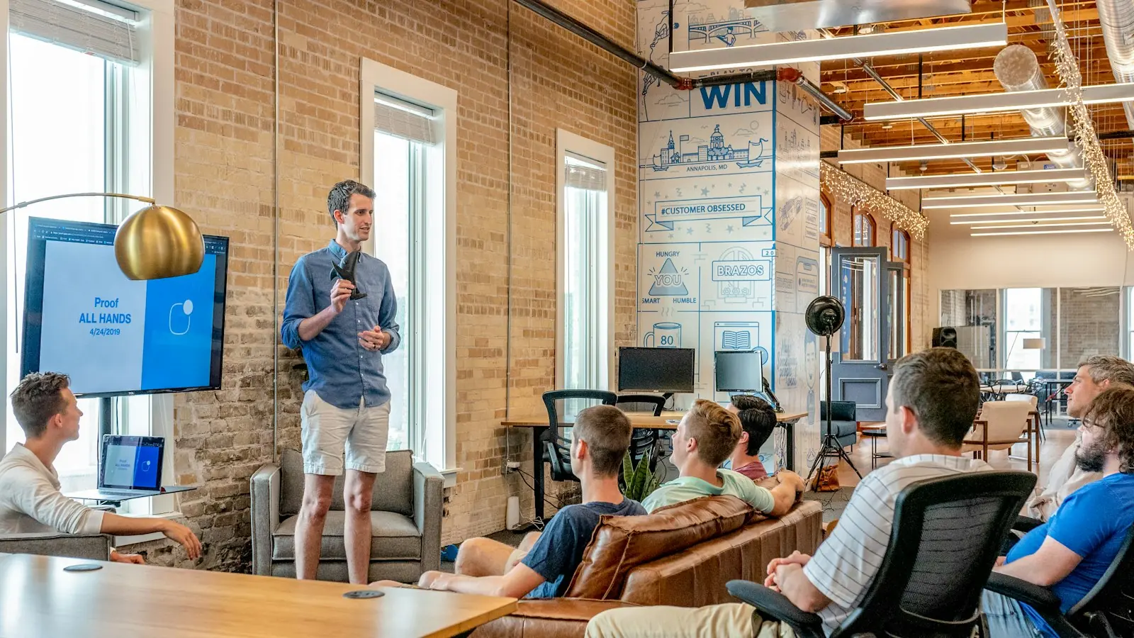 Team members listening to a presentation in a bright studio