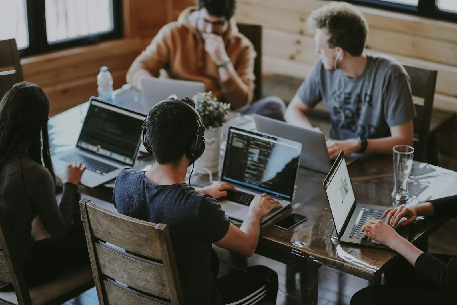 A team collaborating around a table with laptops